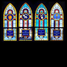 Four memorial windows designed for church sacristy, created in cathedral and water glass with painted medallions and acid-etched nameplates.